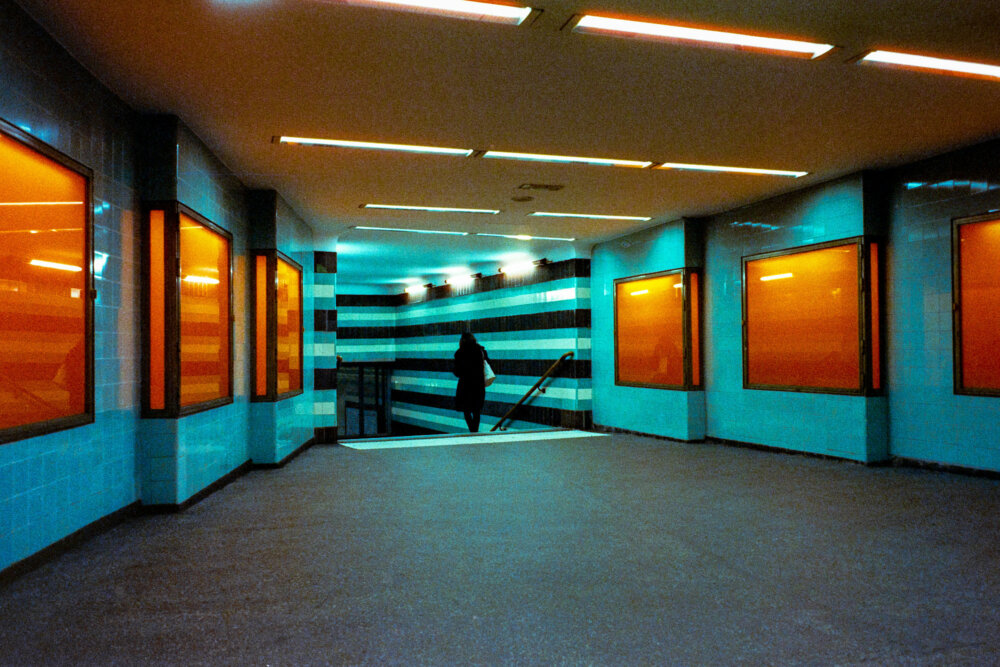 a woman walking down the stairs of a subway station